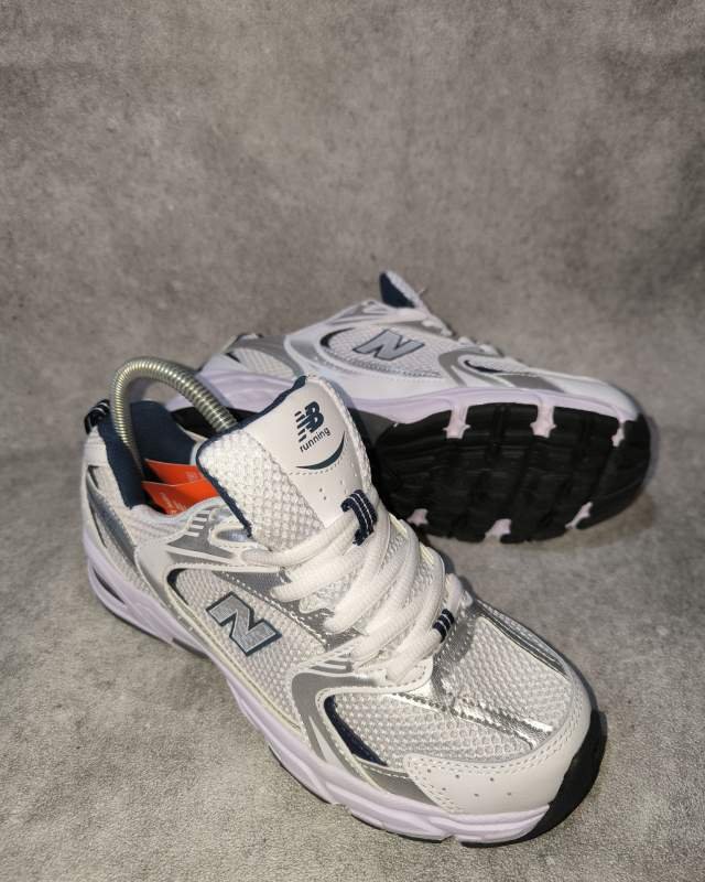 New Balance 1906R (terlihat lidah sepatu bertuliskan NB Running 1906 dan desain upper berbahan mesh dengan struktur overlay sintetis perak/silver)