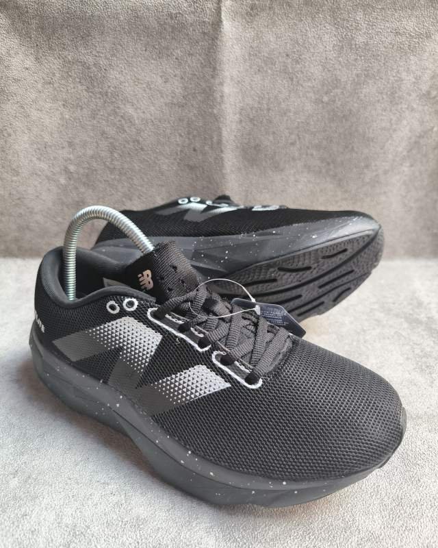 New Balance New Balance FuelCell / Fresh Foam (terlihat logo besar 'N' khas New Balance berbentuk garis-garis geometric/oversized di bagian samping bodi mesh, serta aksen bintik-bintik speckled pada sol luar)