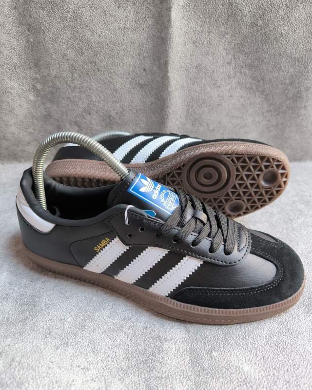 Adidas Adidas Samba OG (sepatu lifestyle/sneakers klasik ikonik berdesain low-cut berbahan kulit warna hitam dengan lapisan suede T-toe di bagian depan, tiga garis khas Adidas (3-Stripes) berwarna putih, serta tulisan foil emas 