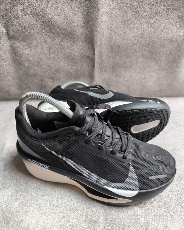 Nike Nike Vomero 17 (sepatu lari daily trainer dengan bantalan busa ganda ZoomX yang tertulis di sisi sol belakang dan Cushlon, serta logo Swoosh putih di bagian samping)  Warna: Black / White / Sail (Bodi upper mesh warna hitam dengan logo Swoosh putih dan ba