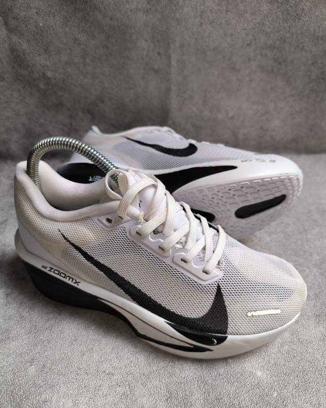 Nike Nike Vomero 17 (sepatu lari daily trainer dengan kombinasi bantalan busa ZoomX yang tertulis di sisi sol belakang serta Cushlon, dan logo Swoosh hitam di bagian samping)