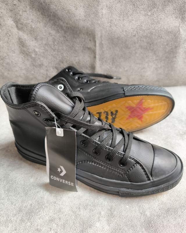 Converse Converse Chuck Taylor All Star Leather High/Mid (sepatu lifestyle/casual klasik berpotongan tinggi berbahan kulit/leather hitam, dilengkapi label tag Converse, serta sol bawah karet warna cokelat gum dengan logo bintang merah khas Converse di bagian bawah
