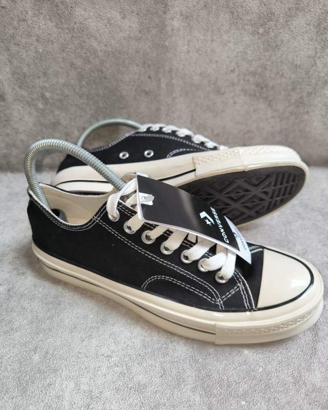 Converse Converse Chuck 70 Low / Ox (sepatu lifestyle/casual klasik berpotongan rendah (low-top) berbahan kanvas tebal warna hitam, dilengkapi sol midsole berwarna krem/egret yang lebih tinggi dan mengilap, jahitan kontras putih di bagian samping, serta tag/patch 