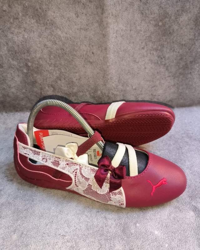 Puma Puma Speedcat Ballet / Mary Jane (sepatu gaya ballerina / mary-jane flat berbahan kulit/sintesis berwarna merah marun (maroon/burgundy), dilengkapi tali pita maroon di atas lidah, aksen brokat lace bermotif di sisi samping, serta logo Puma Cat khas di bag
