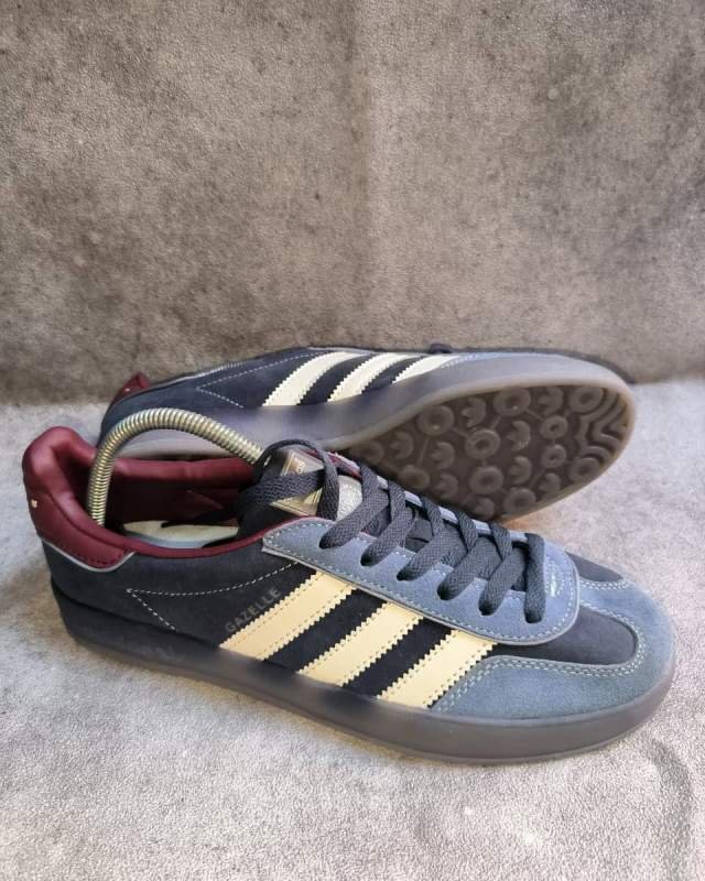 Adidas Adidas Gazelle Indoor (sepatu lifestyle/casual klasik berbahan suede abu-abu, dengan tiga garis ikonik Adidas berwarna hitam, kerah belakang/lapisan dalam berwarna merah marun/burgundy, tulisan emas 