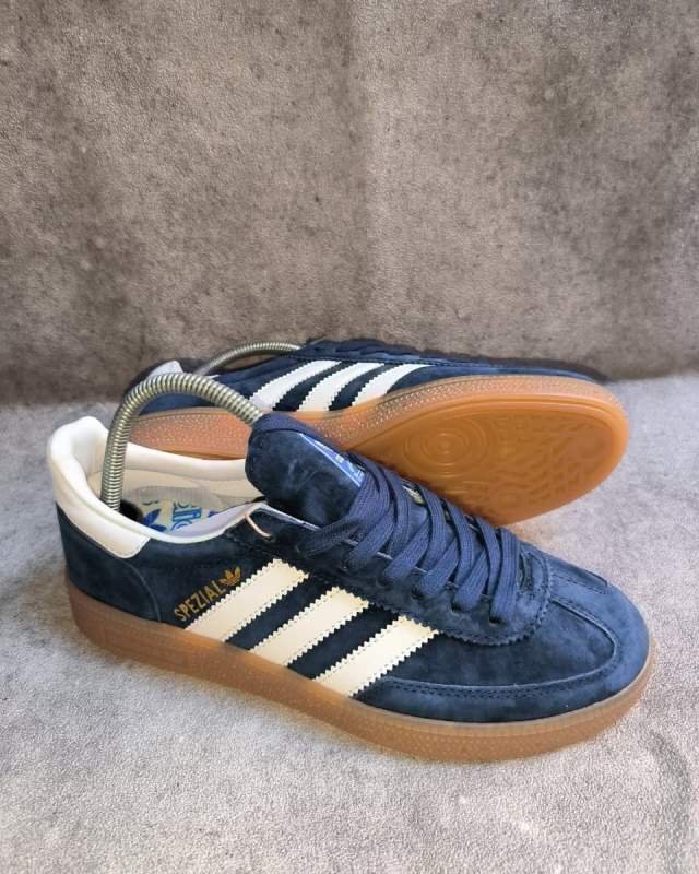 Adidas Adidas Handball Spezial (sepatu lifestyle/casual klasik berbahan suede halus warna biru dongker/navy, dilengkapi tiga garis khas Adidas berwarna putih/krem, sol karet gum, serta tulisan warna emas 