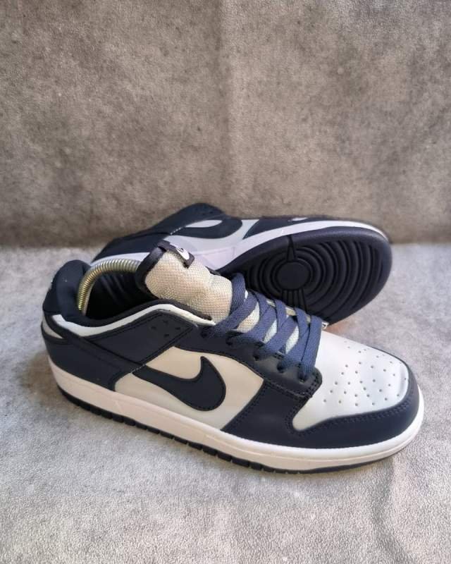 Nike Nike Dunk Low (sepatu sneakers / lifestyle klasik berbahan kulit dengan aksen lidah bertuliskan logo Nike Dunk, serta kombinasi warna dua nada / two-tone yang ikonik)