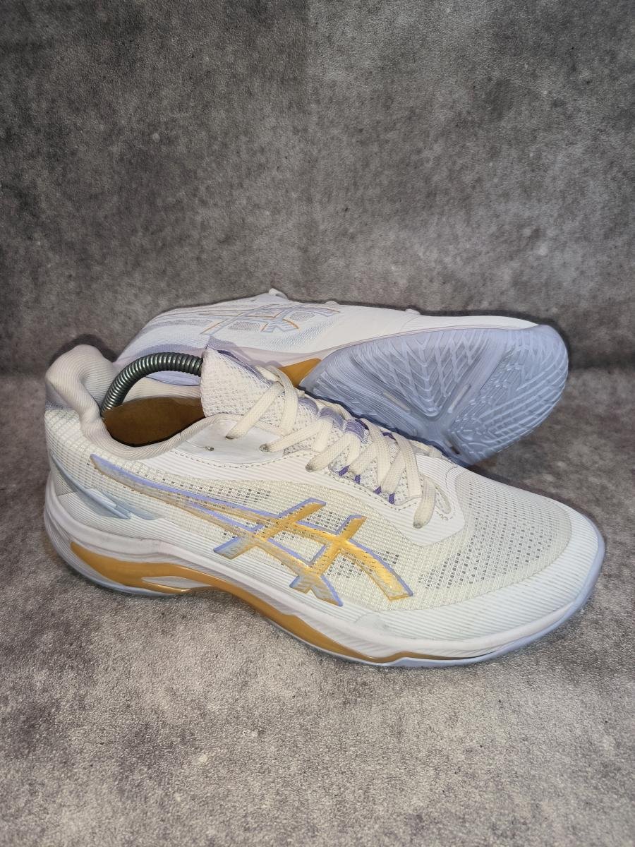 Asics Netburner Ballistic FF 4 berwarna putih dengan aksen garis khas berwarna emas champagne
