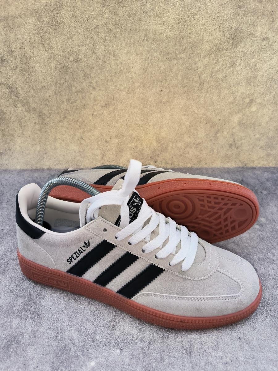 Adidas Handball Spezial berwarna krem dengan aksen tiga garis hitam klasik dan sol karet gum