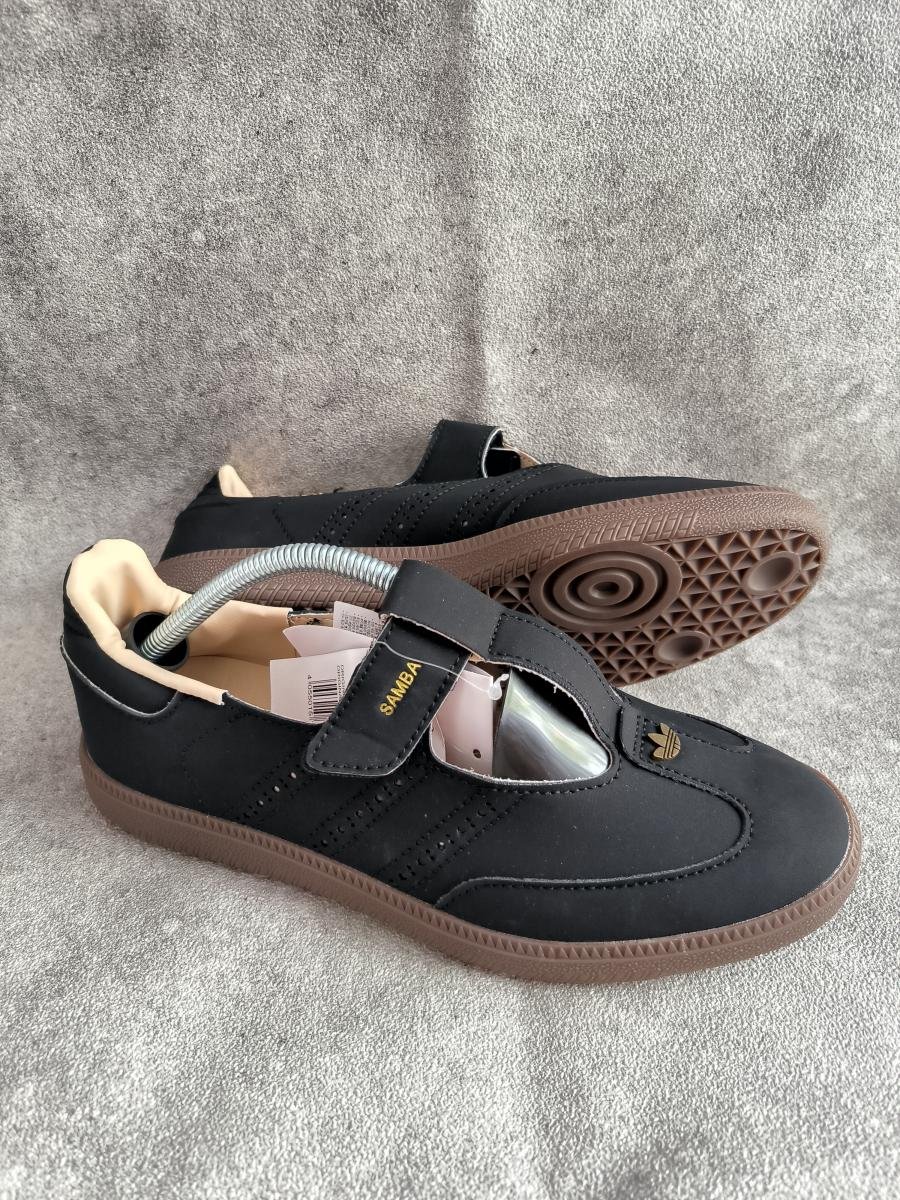 Adidas Samba Jane berwarna hitam legam berdesain Mary Jane yang dilengkapi strap Velcro dan sol gum khas