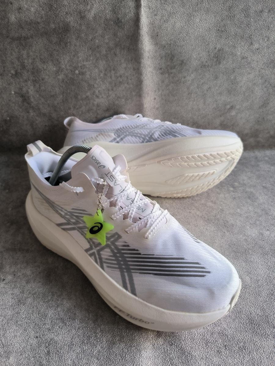 Asics Megablast warna White / Piedmont Grey.